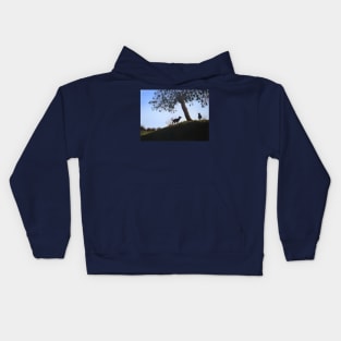 cone tree on hillside with dogs playing Kids Hoodie